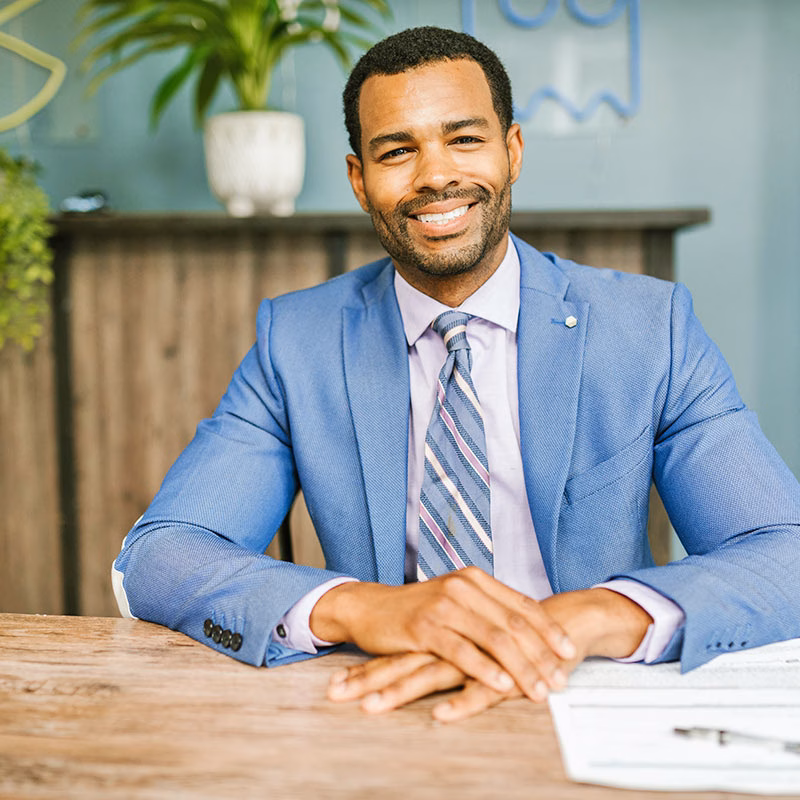 Man Sitting at Table and Smiling Man Sitting at Table and Smiling